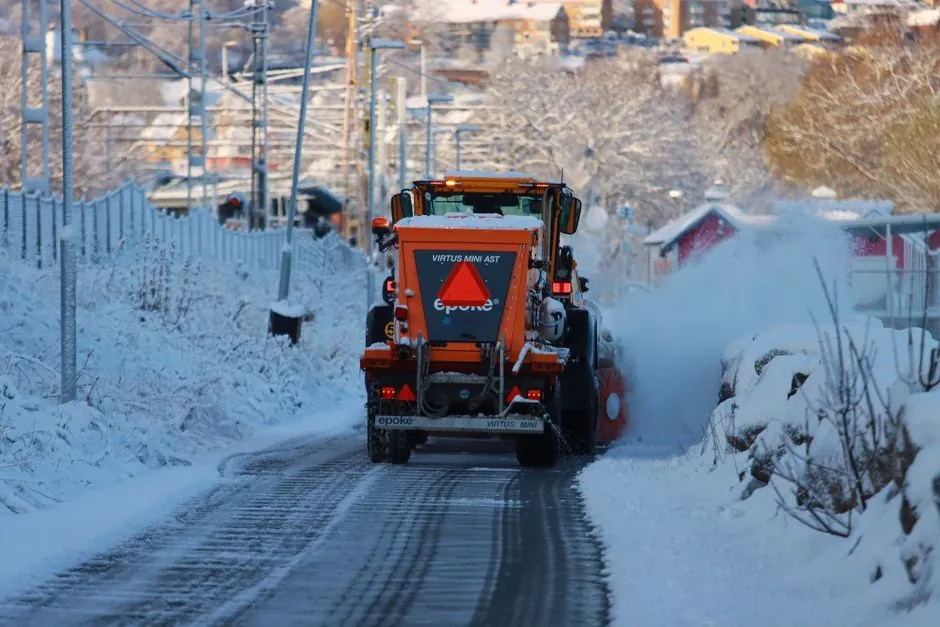 A snow plow clears a snow-covered street in Jönköping, Sweden, during winter.
