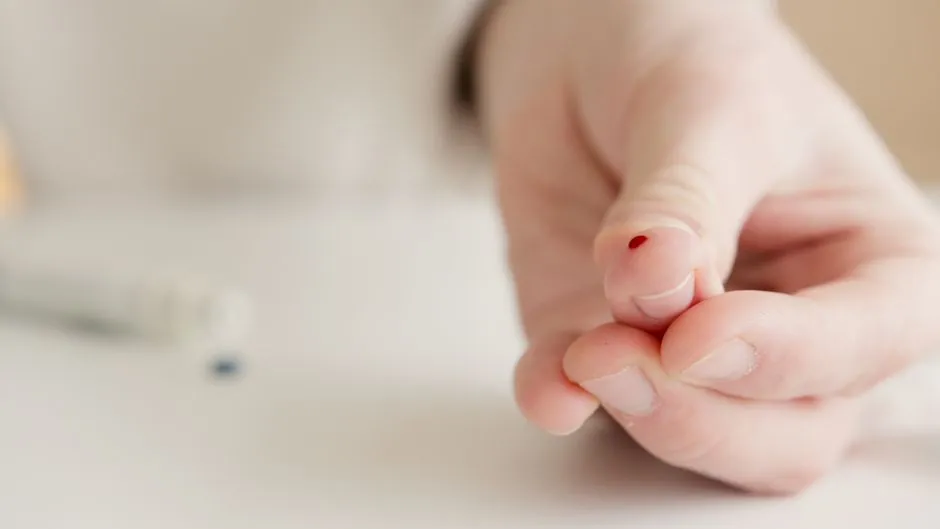 Close-up of a hand with a finger prick for home blood testing. Ideal for health and medical themes.